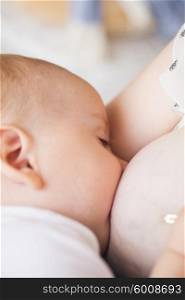 Breastfeeding of seven month baby, closeup child face with closed eyes, sleeping