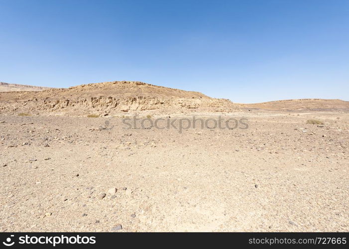 Breathtaking landscape of the rock formations in the Israel desert. Dusty mountains interrupted by wadis and deep craters.