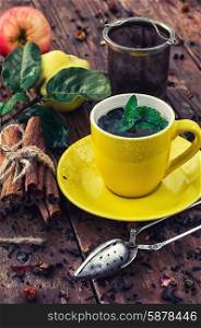 brew tea. Cup of brewed herbal tea on wooden background strewn with tea leaves