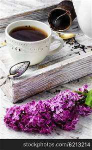 Brewed herbal tea. Cup of herbal medicinal tea kettle and bunch of lilac blossoms
