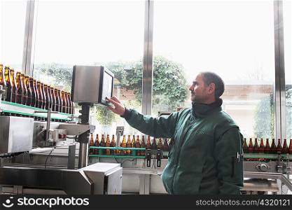 Brewery worker operating bottling machine