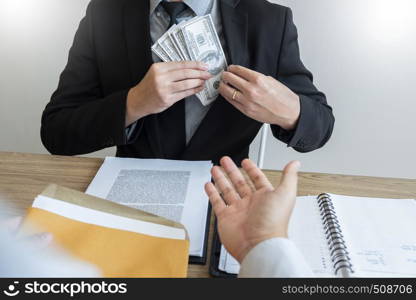 bribe and corruption concept, Corrupted businessman sealing the deal hand receiving venality bribe money from partner.