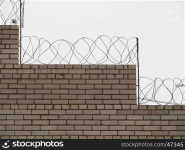 brick fence with barbed wire