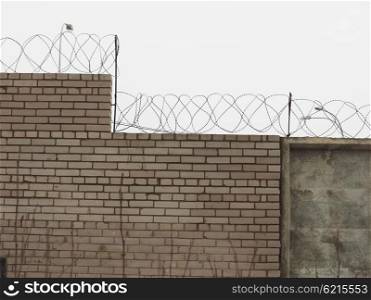 brick fence with barbed wire