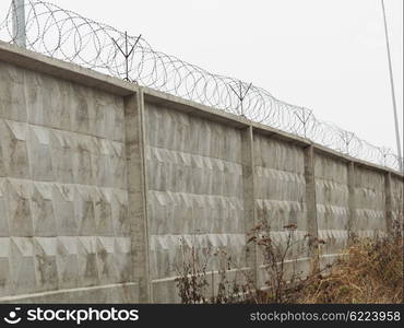 brick fence with barbed wire