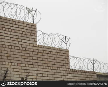 brick fence with barbed wire