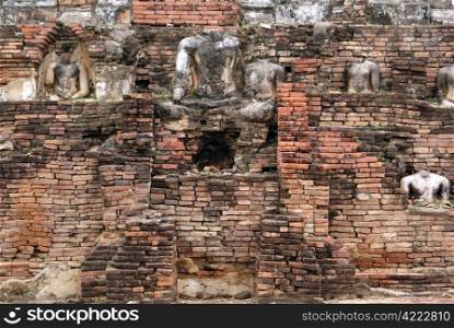 Brick wall and Buddhas in wat, Sukhotai, Thailand
