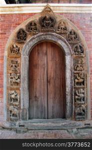 Brick wall and wooden door of temple in Patan, Nepal