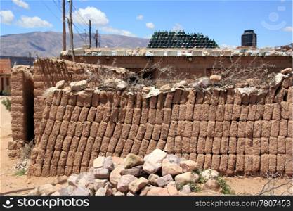 Brick wall, house and wine bottles in desert village
