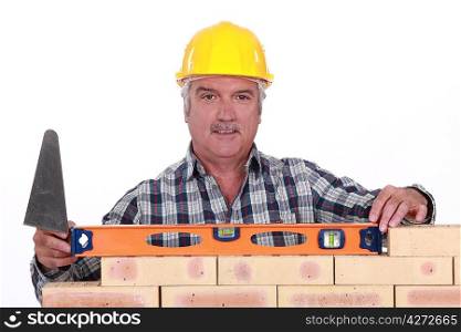 Bricklayer checking the level of a wall