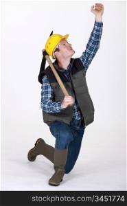 bricklayer holding pickaxe looking upwards
