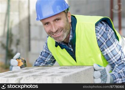bricklayer putting down another row of bricks in site