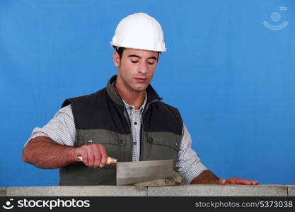 Bricklayer using trowel