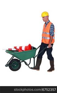 bricklayer with wheelbarrow and construction cone