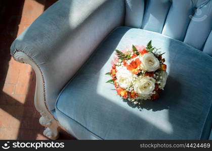 Bridal bouquet in soft antique chair from blue velvet