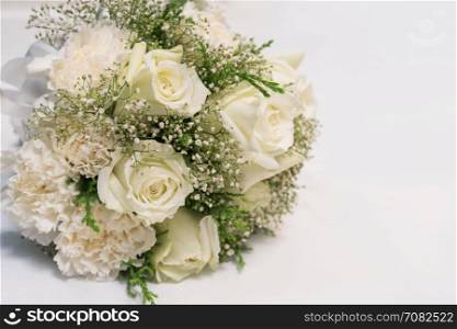 Bridal bouquet of white rose on white fabric background