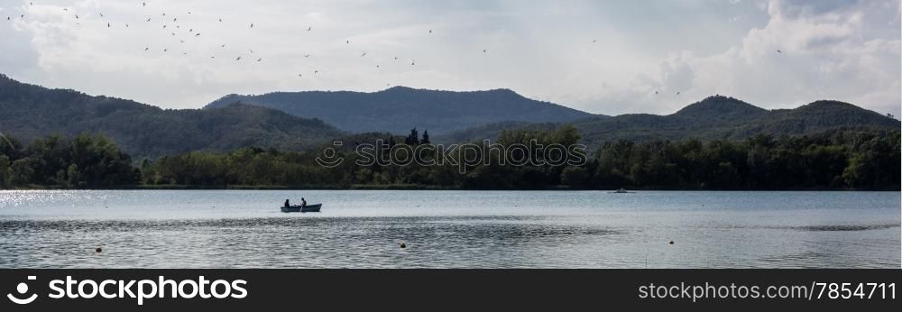 Bridal couple walking on the lake with a boat