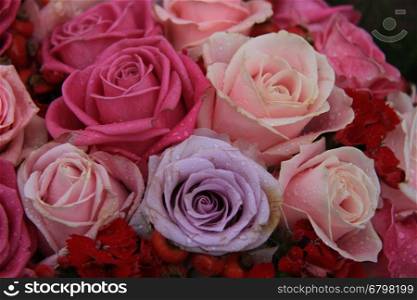 Bridal flower arrangement in various shades of pink and purple, mixed with red berries
