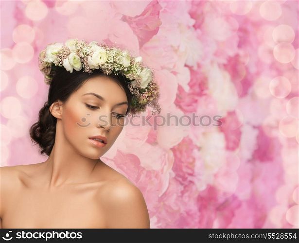 bridal, spring and beauty concept - young woman wearing wreath of flowers on floral background
