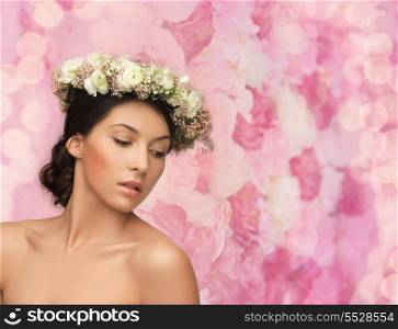 bridal, spring and beauty concept - young woman wearing wreath of flowers on floral background