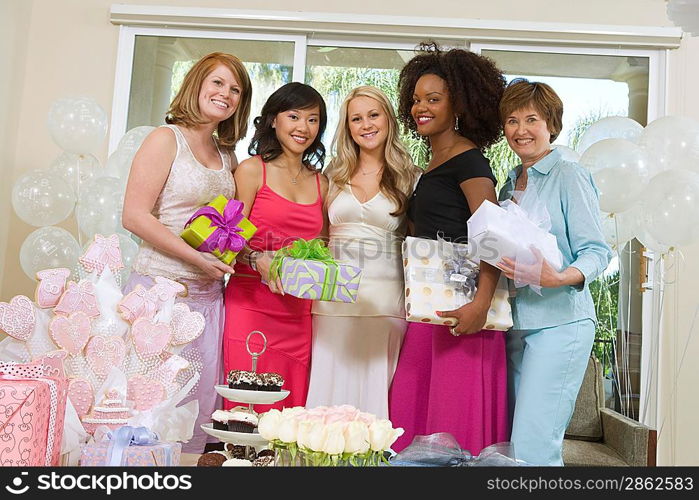 Bride and Friends standing Together holding gifts at Bridal Shower