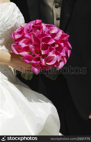 Bride and groom. Closeup on wedding bouquet.