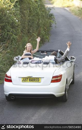 Bride And Groom Driving Away In Decorated Car