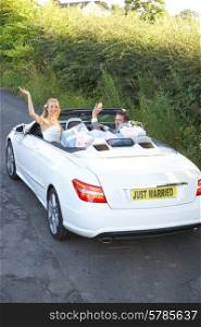 Bride And Groom Driving Away In Decorated Car