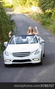 Bride And Groom Driving Away In Decorated Car