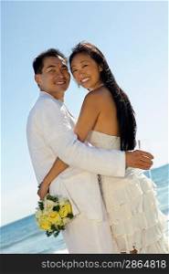 Bride and Groom Embaracing on Beach
