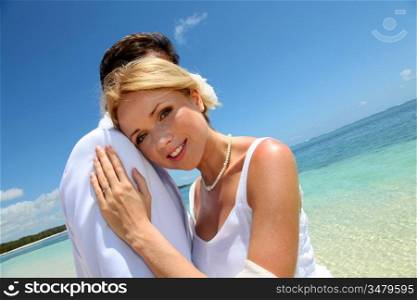 Bride and groom embracing by the sea