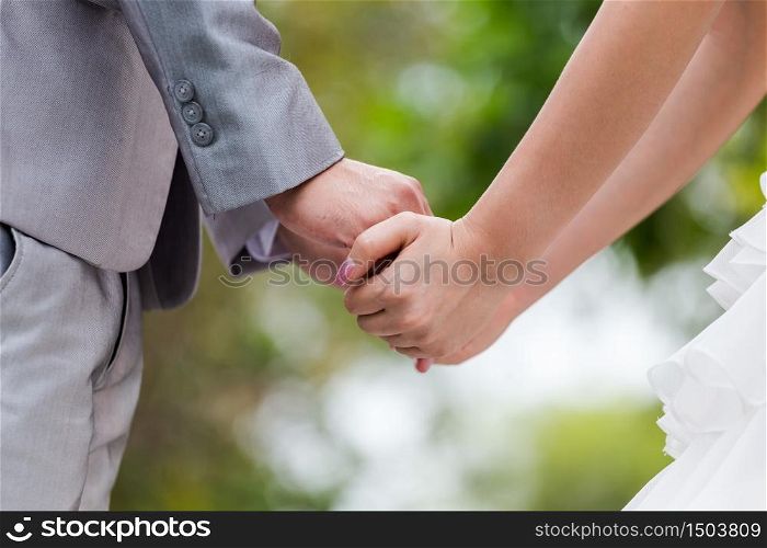 Bride and groom holding hands in wedding celemony a symbol of love