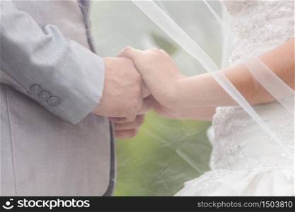 Bride and groom holding hands in wedding celemony a symbol of love