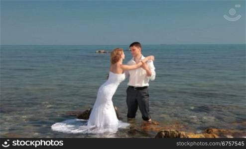 bride and groom hugging at beach
