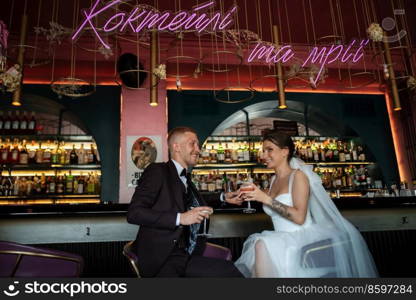 bride and groom inside a cocktail bar in a vibrant atmosphere