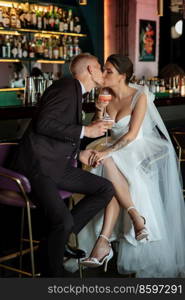 bride and groom inside a cocktail bar in a vibrant atmosphere