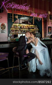 bride and groom inside a cocktail bar in a vibrant atmosphere