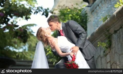 bride and groom kissing in park