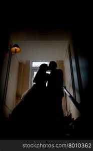 Bride and groom kissing silhouette on their wedding