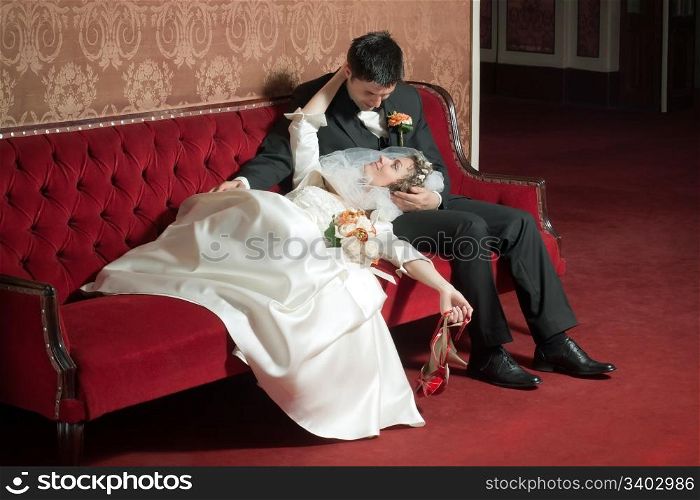 Bride and groom looking at each other on a sofa