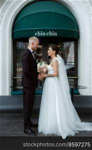 bride and groom near the cafe on the street of the summer city