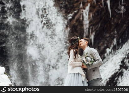 bride and groom on the background of a mountain waterfall