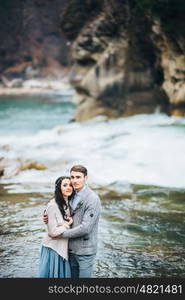 bride and groom on the background of a mountain waterfall