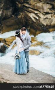 bride and groom on the background of a mountain waterfall