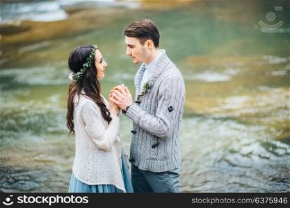 bride and groom on the background of a mountain waterfall