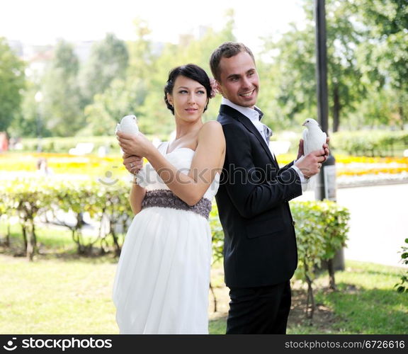 Bride and groom ready to let pigeons free during the wedding walk