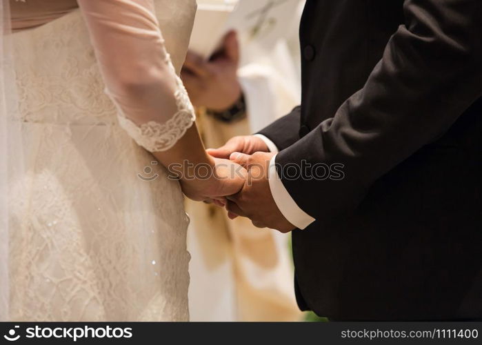 Bride and groom rings at the ceremony. Bride and groom holding hands