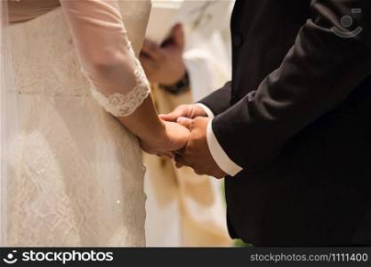 Bride and groom rings at the ceremony. Bride and groom holding hands