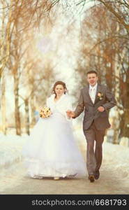 bride and groom running on a footpath