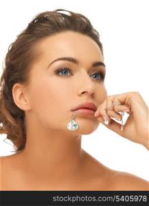 bride and wedding concept - beautiful woman holding shiny diamond pendant in mouth